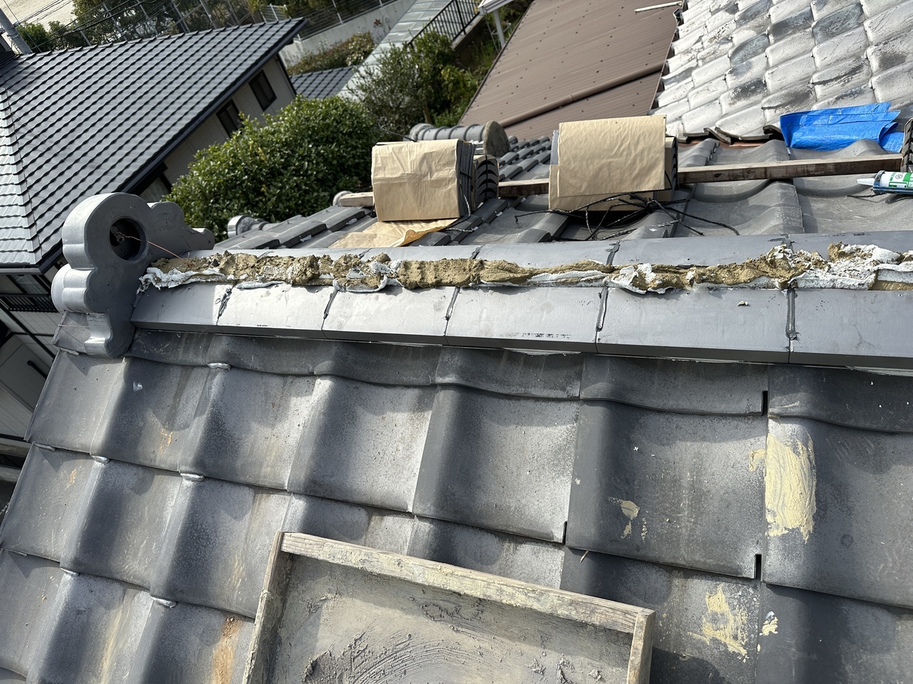 北九州の瓦修理：土を糊代わりにしてのし瓦を積み、鬼首を番線で強固に固定する棟瓦の施工