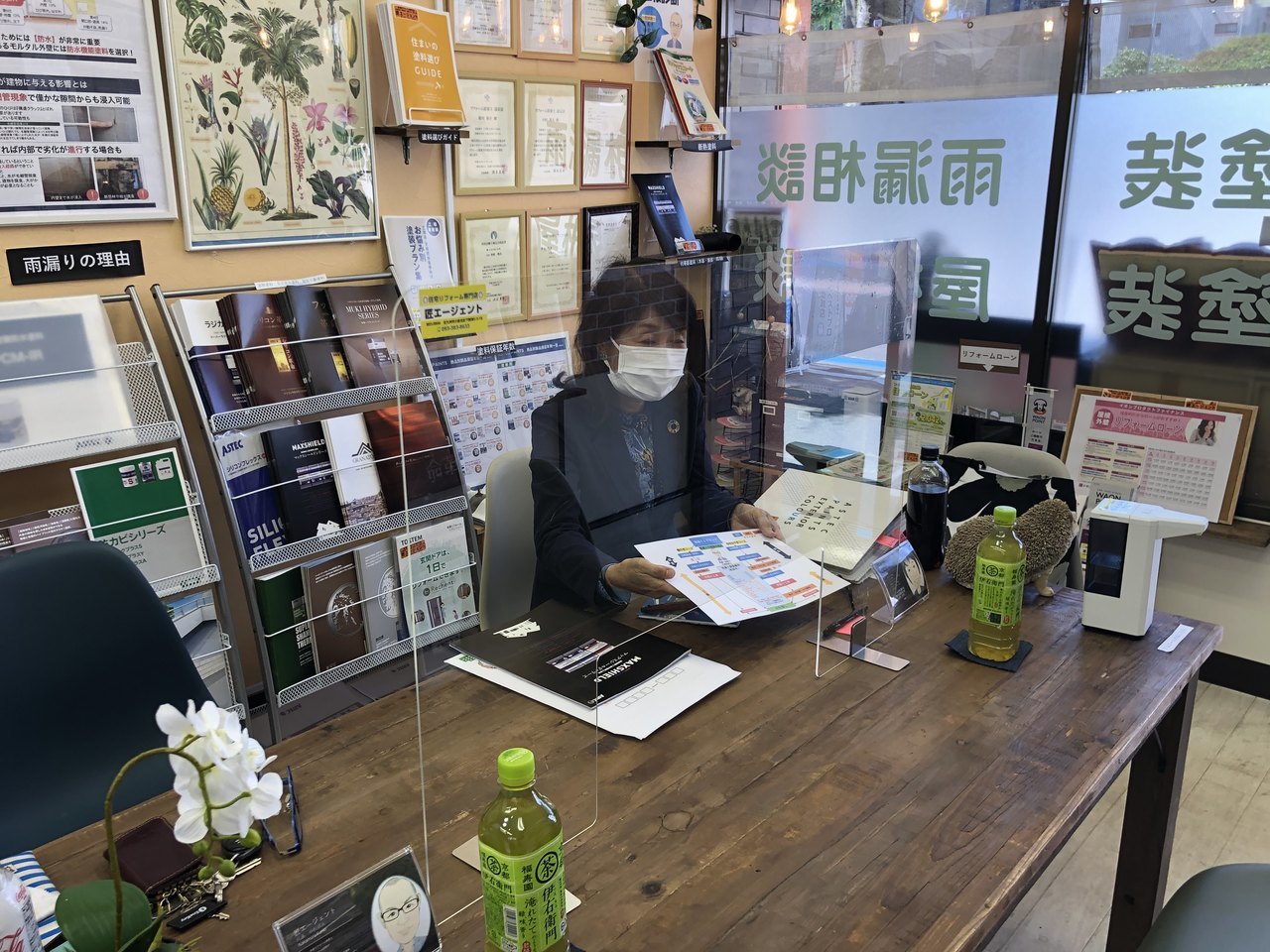 匠エージェントの店舗で、屋根塗装の診断結果に基づいた見積りプランを説明する様子。北九州の住宅に合わせた塗料選び。